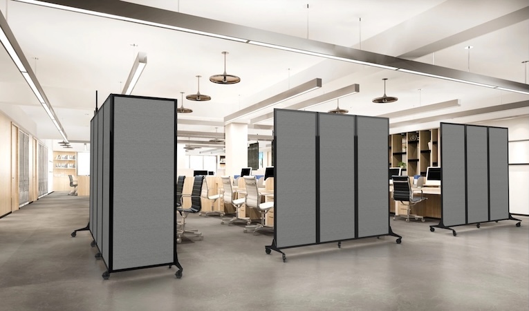 Gray mobile partitions create flexible work areas in an open-plan office.