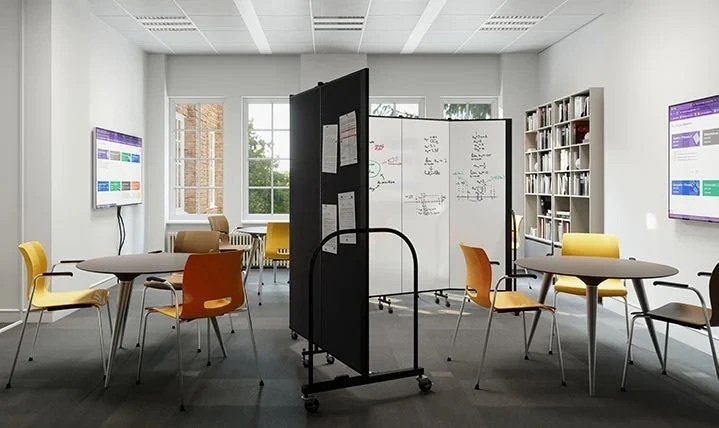 Dry-erase and tackable divider positioned between collaborative library tables.