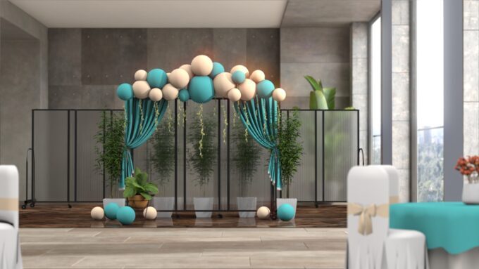 Polycarbonate room dividers decorated with teal drapes and balloons for an office party backdrop.
