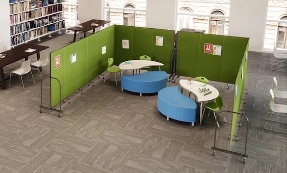 Library Dividers Green Screenflex dividers surrounding tables and curved seating in a children’s library area.