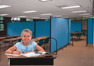 Female student sitting and a desk doing school work in a Multi Purpose Room