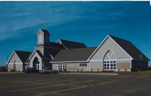 A church building in the rear of a large parking lot