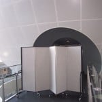 An accordion room divider blocks the entrance to a history exhibit