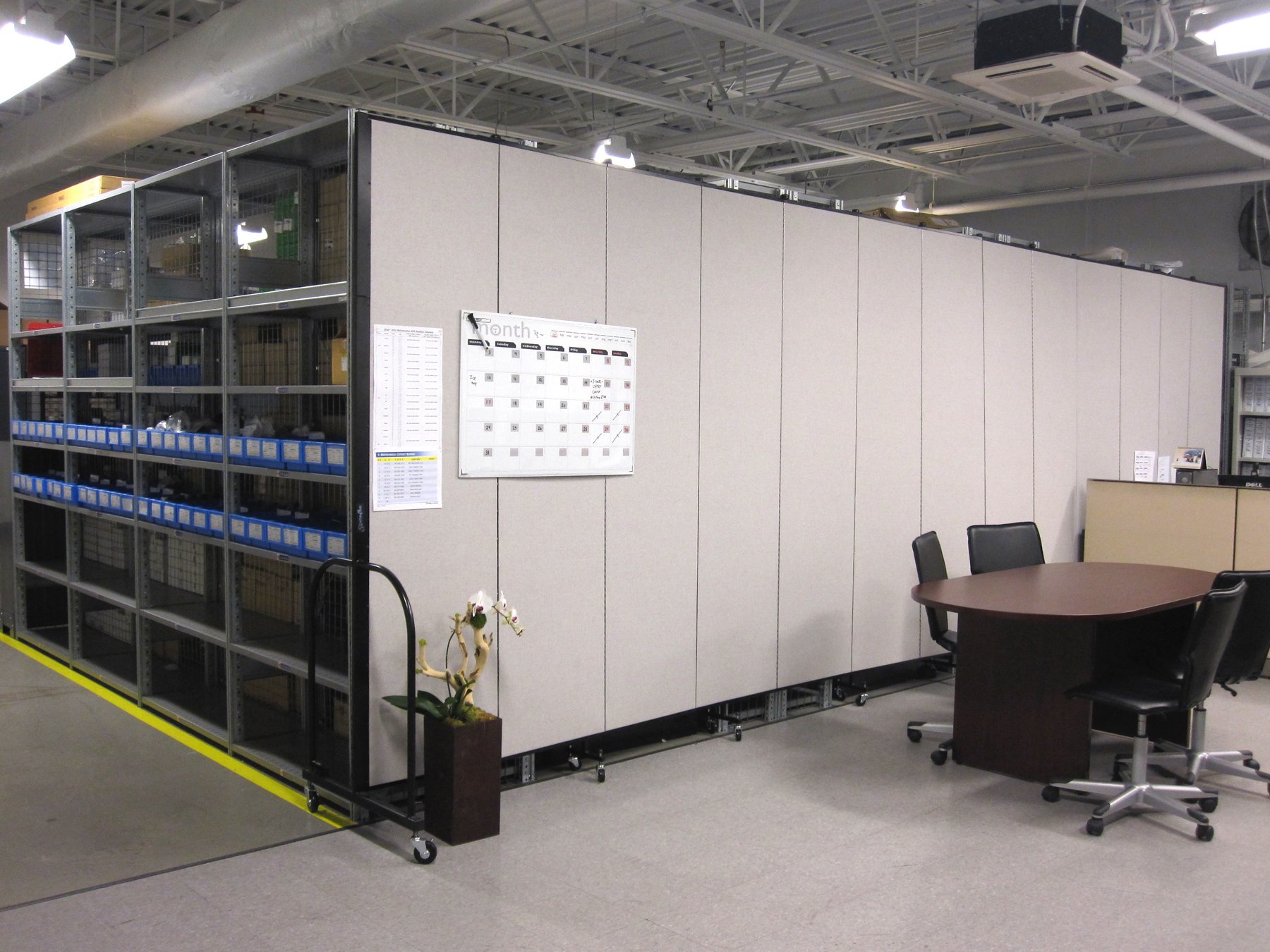 Warehouse office divider behind a meeting desk in the warehouse