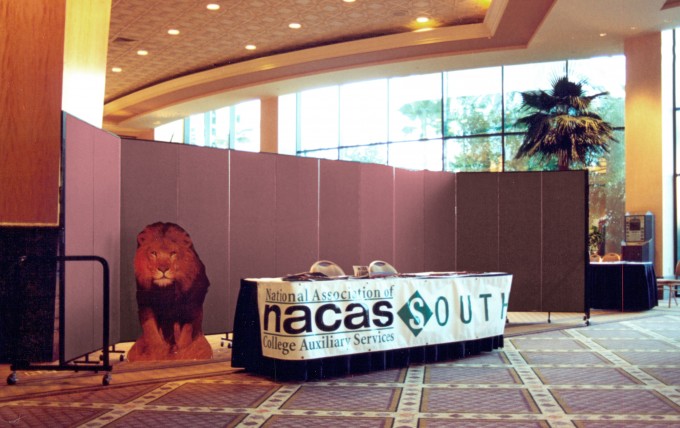 To help provide some scerenity to the registration process in this busy Casino lobby, this facility manager rolled a Screenflex Portable Freestanding Divider into place registration table at convention
