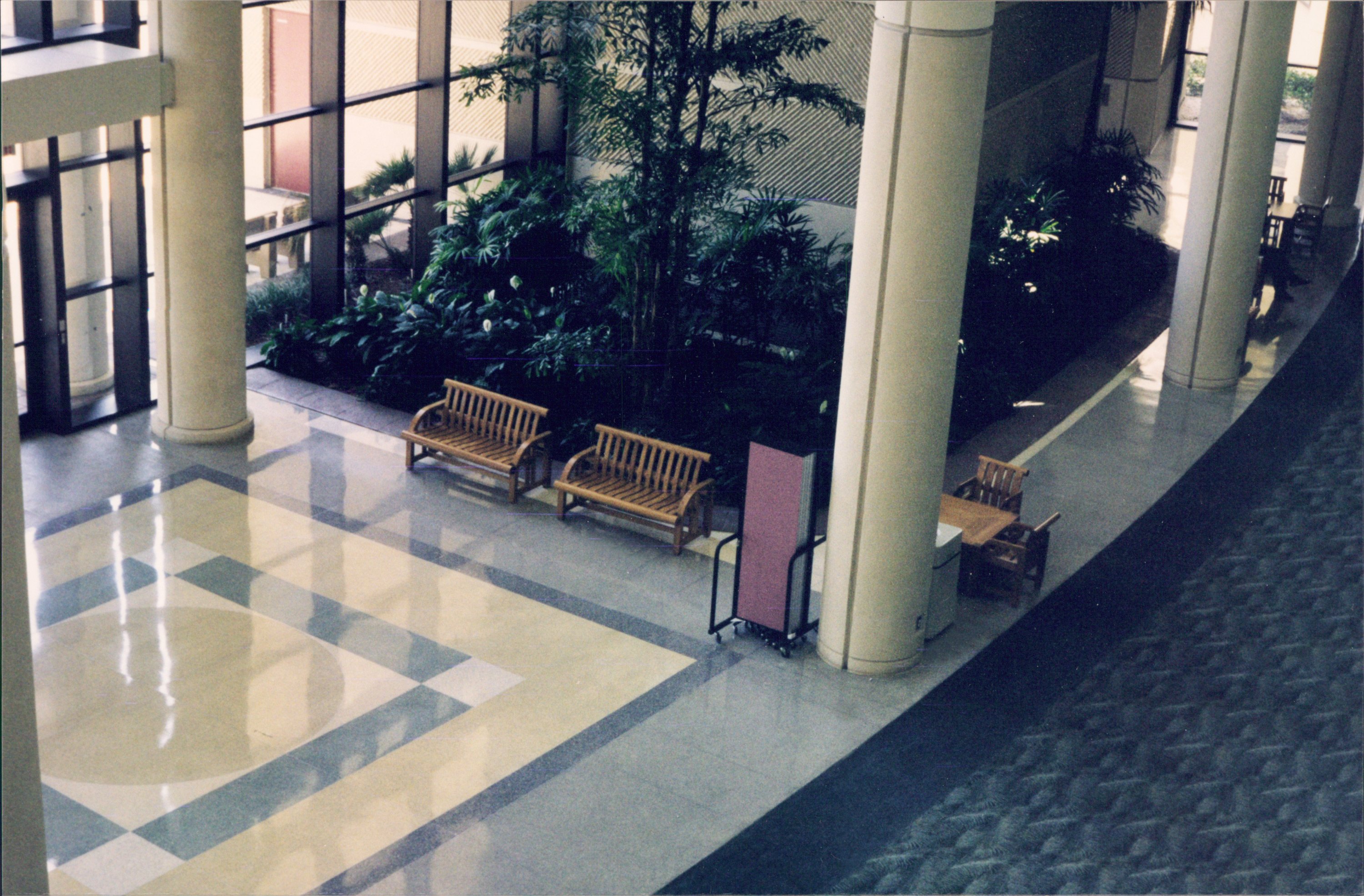 A folded room divider rests next to a column in a hotel lobby