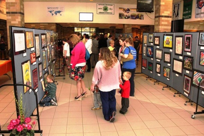 Guests view art tacked to art display panels 