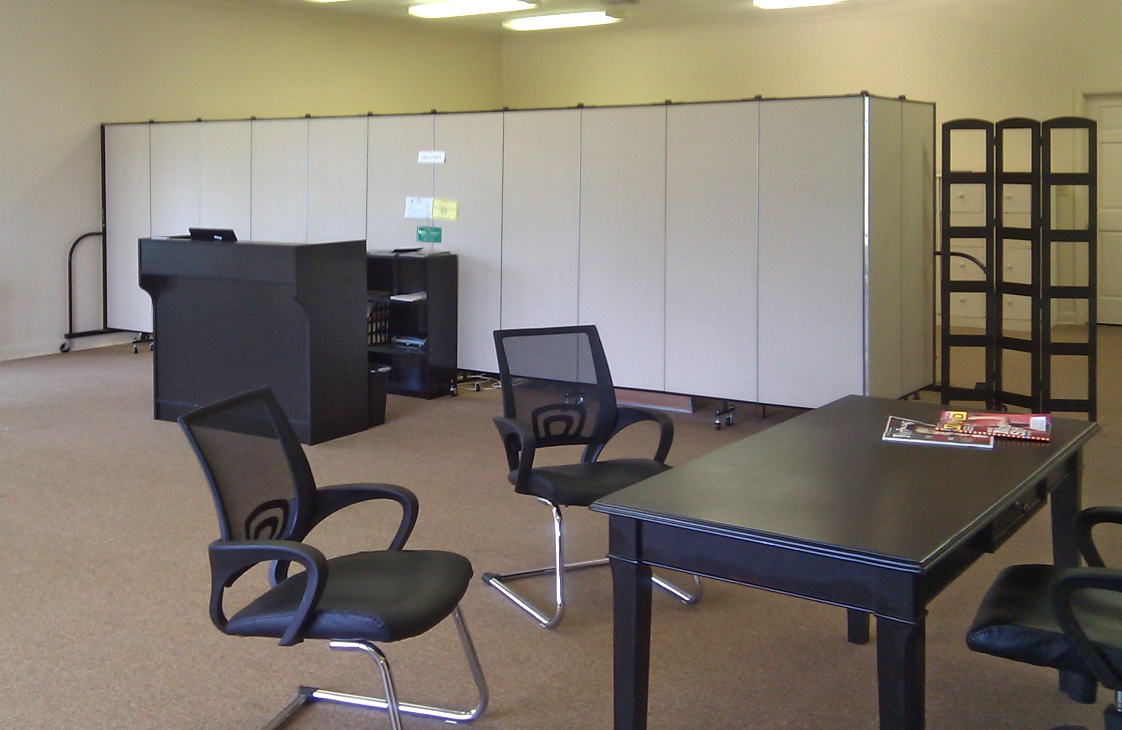 A room divider is used to create private office in the rear of open office space