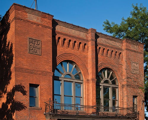 A view of the exterior of an old fire station brick building
