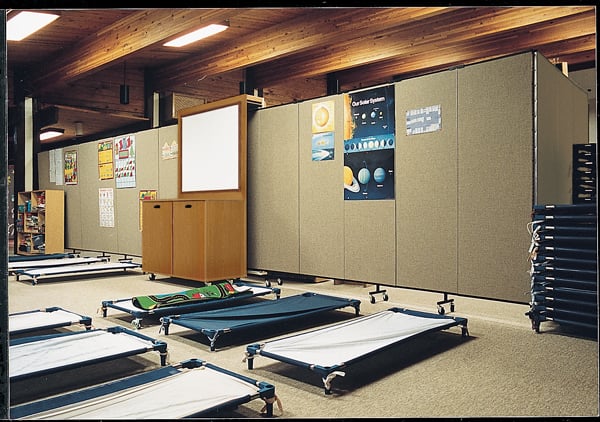 A P.A.D.S. shelter uses Screenflex products to secure sleeping costs from the view of guests A room divider cabinet is used to hide the view of sleeping cots from the guests at the local P.A.D.S. shelter