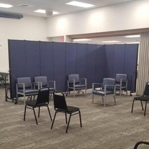 blue room divider creates an l-shape around chairs for privacy