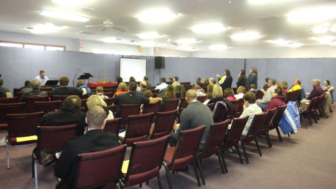 Church dividers surround people in chairs at a church service