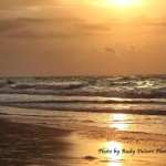 Sunset over rolling waves on a beach