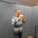 A man sneezing in front of a Screenflex Room Divider