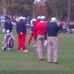 Tiger Woods stands amongst a group of golfers at a PGA Tournament