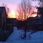 A beautiful sunrise comes over a row of houses.