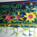 This garden of compliments bulletin board features ivy and colorful flowers