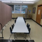 Two set of rectangular tables and chairs are divided into two classrooms with a Screenflex Room Divider