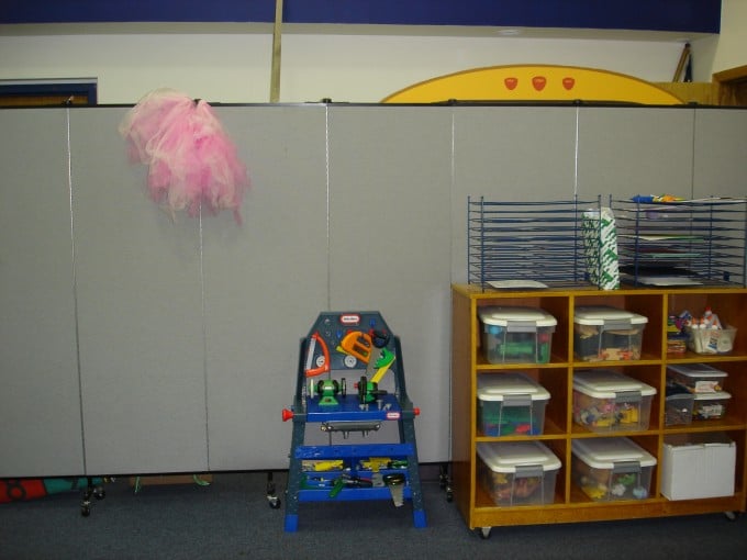 Screenflex Portable Partition Divides a classroom into a play and learning area