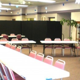 A large fellowship hall is divided into two party rooms with a Screenflex Room Divider