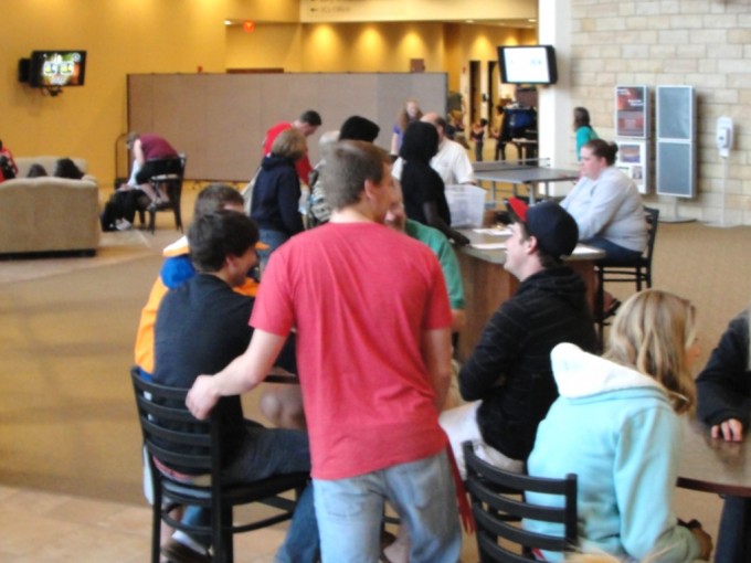 Fellowship hall space occupied by a youth group sitting on chairs around small round tables