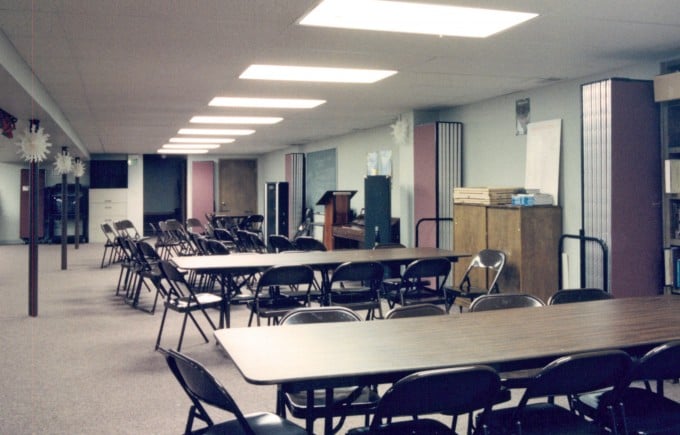 Rows of tables and chairs in a church basement