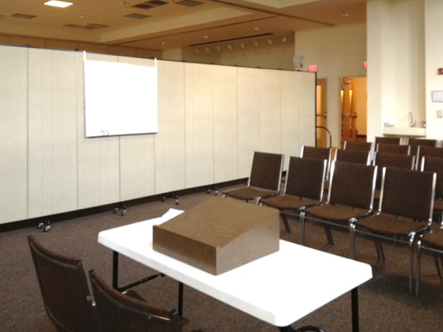 Dry erase board hanging from a room divider in a conference room