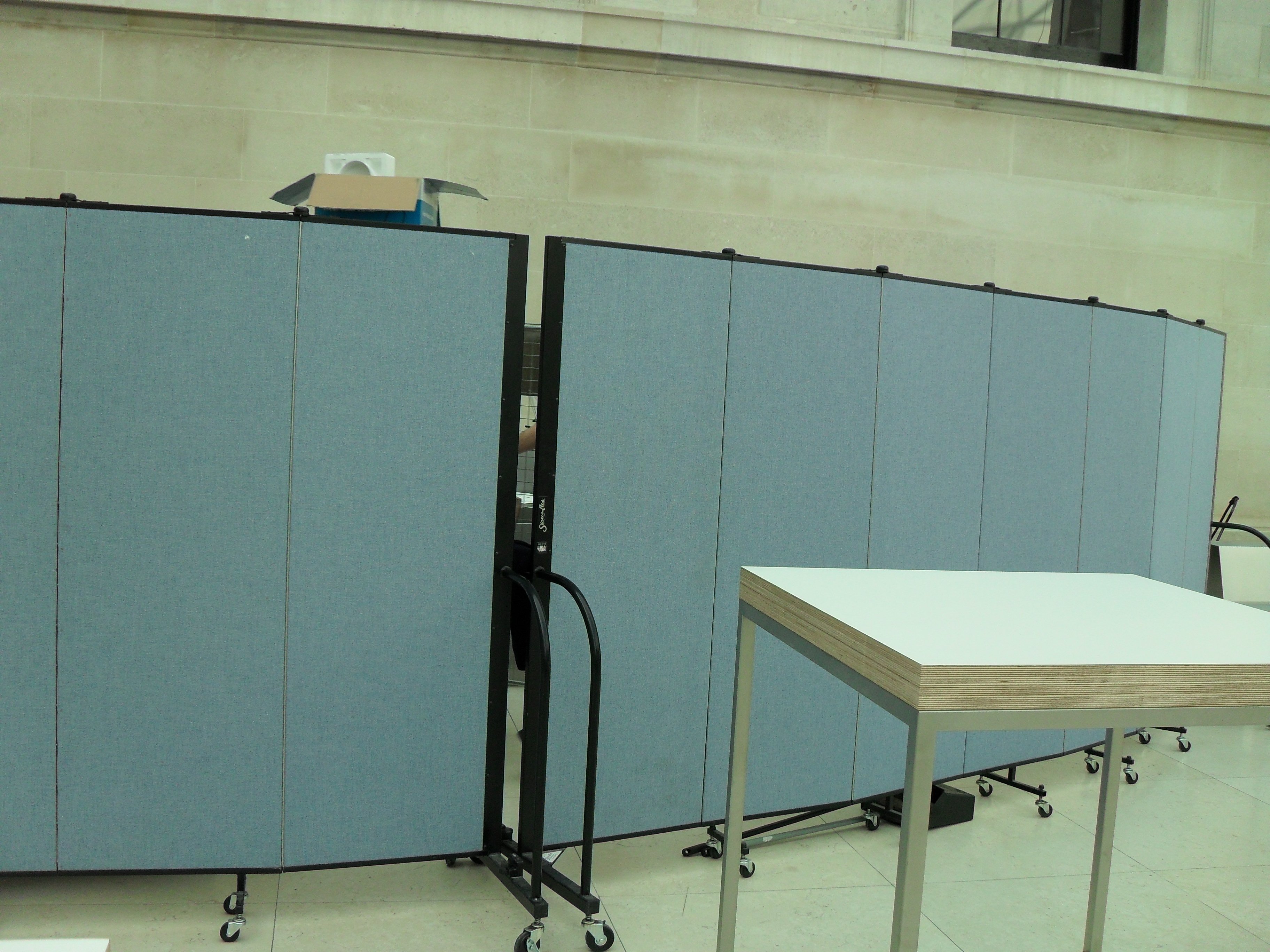 Screenflex Room Divider restrict access to a storage area in a room.