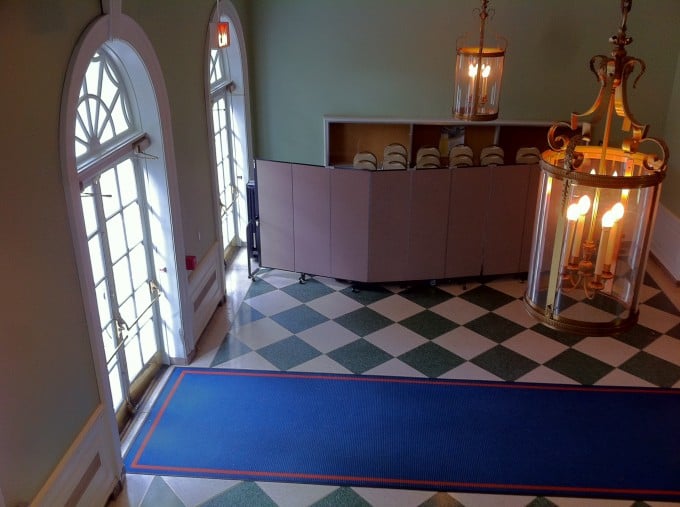 Portable partitions hinding folding chairs in an entryway