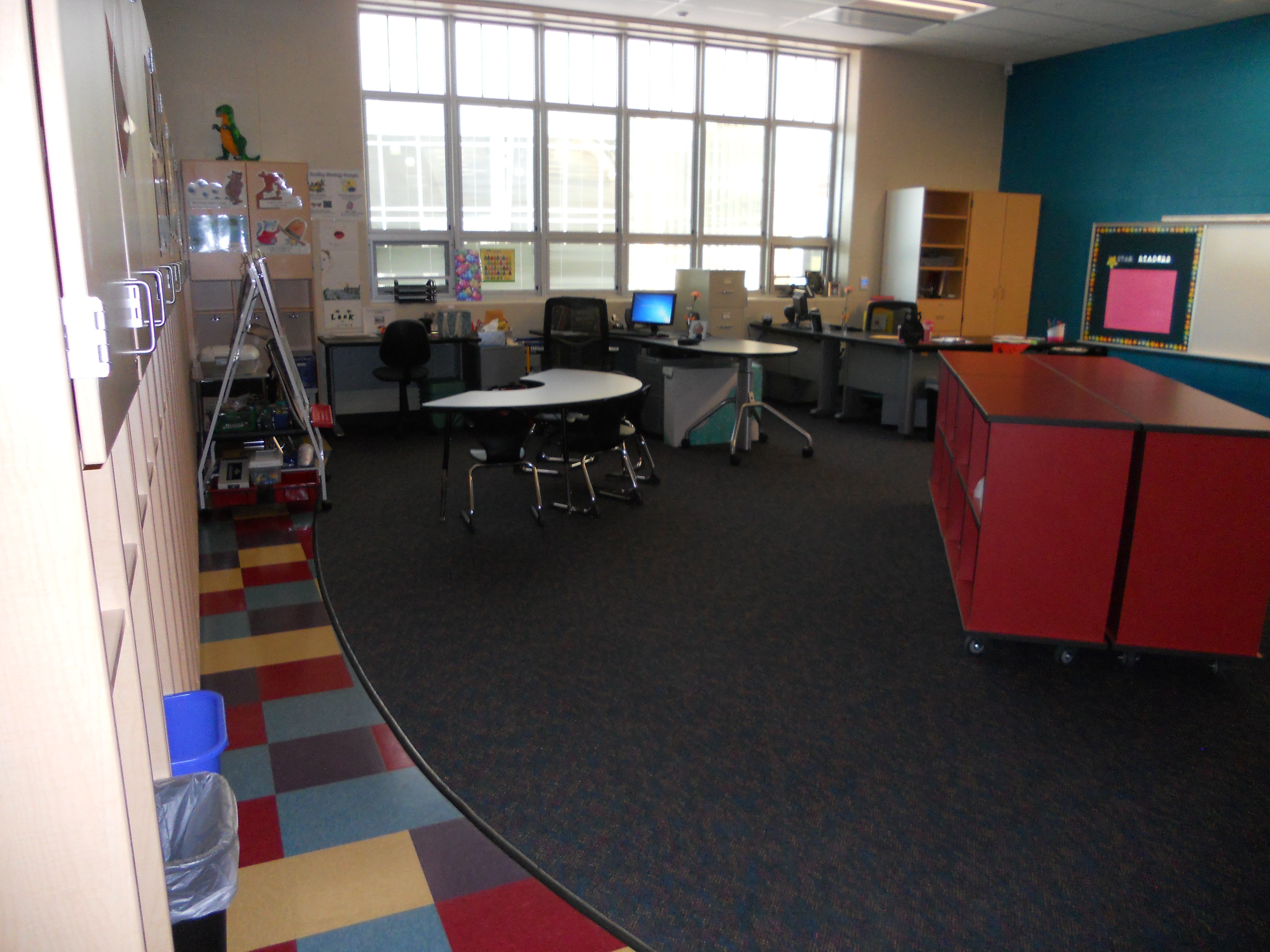 One large classroom cluttered with cabinets and tables and chairs.