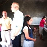Who's taller? A teen girl stands back-to-back with a man to measure her height compared to his christian missionary work