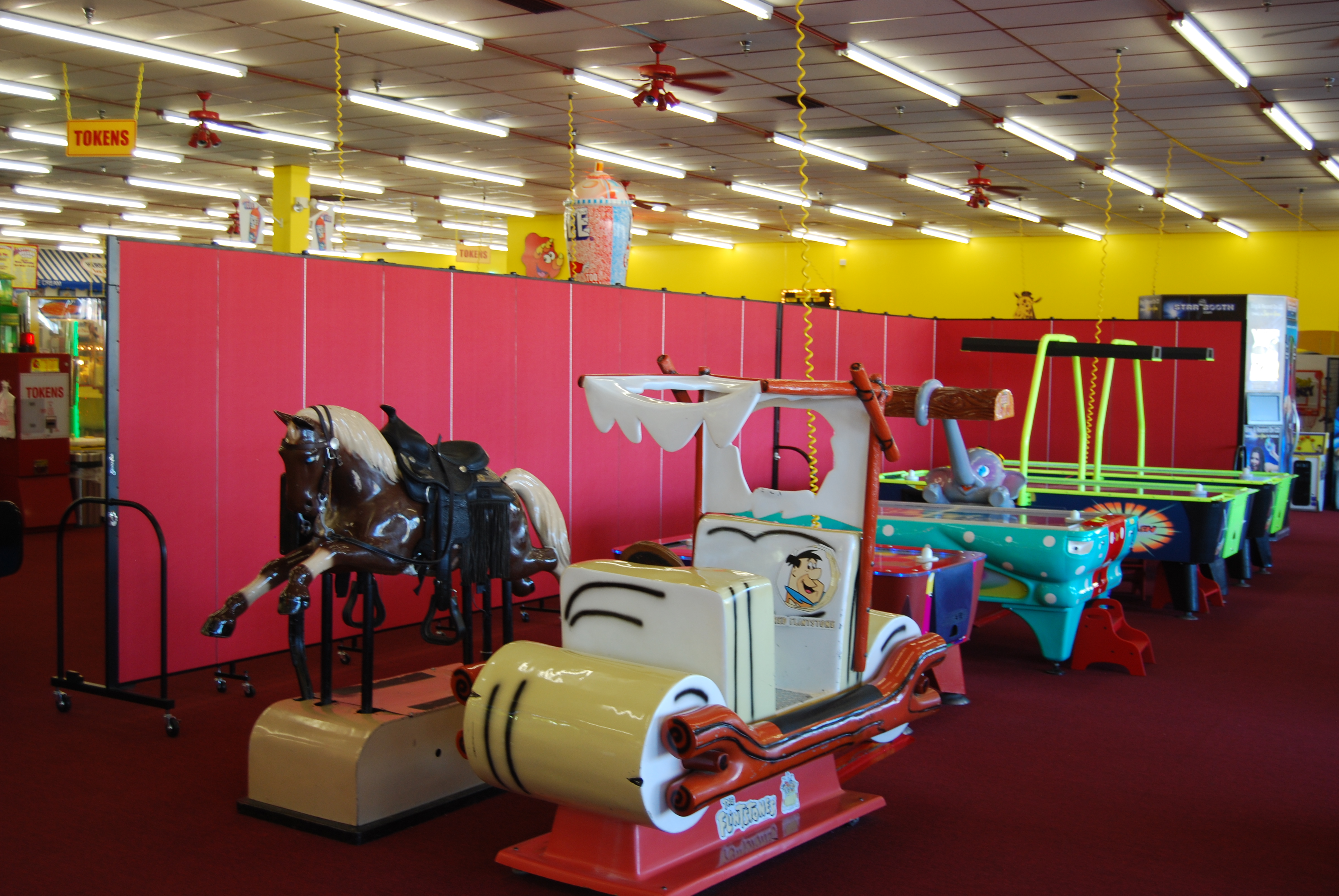 Portable crowd control barrier between concessions and games in a family fun center.