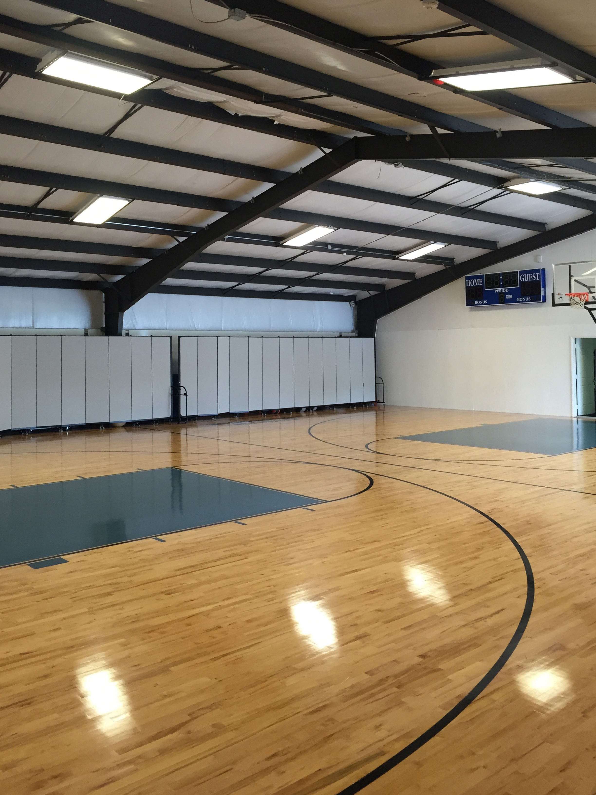 An open gym with room dividers extended along the rear wall