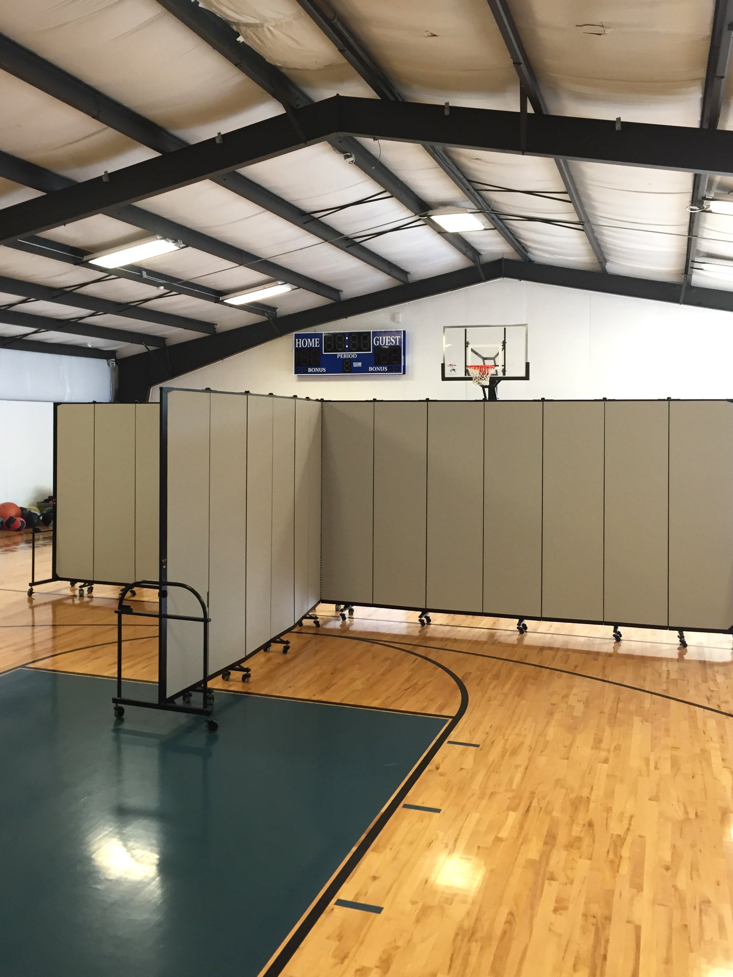 Two room dividers attached to create four classrooms in a gymnasium