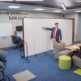 Staff use a moveable office partition to divide meeting space