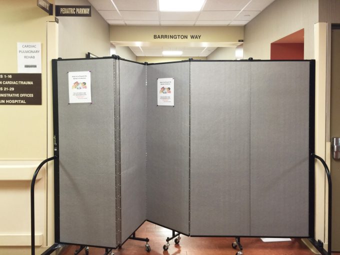 A portable wall separates a hospital hallway into two rooms