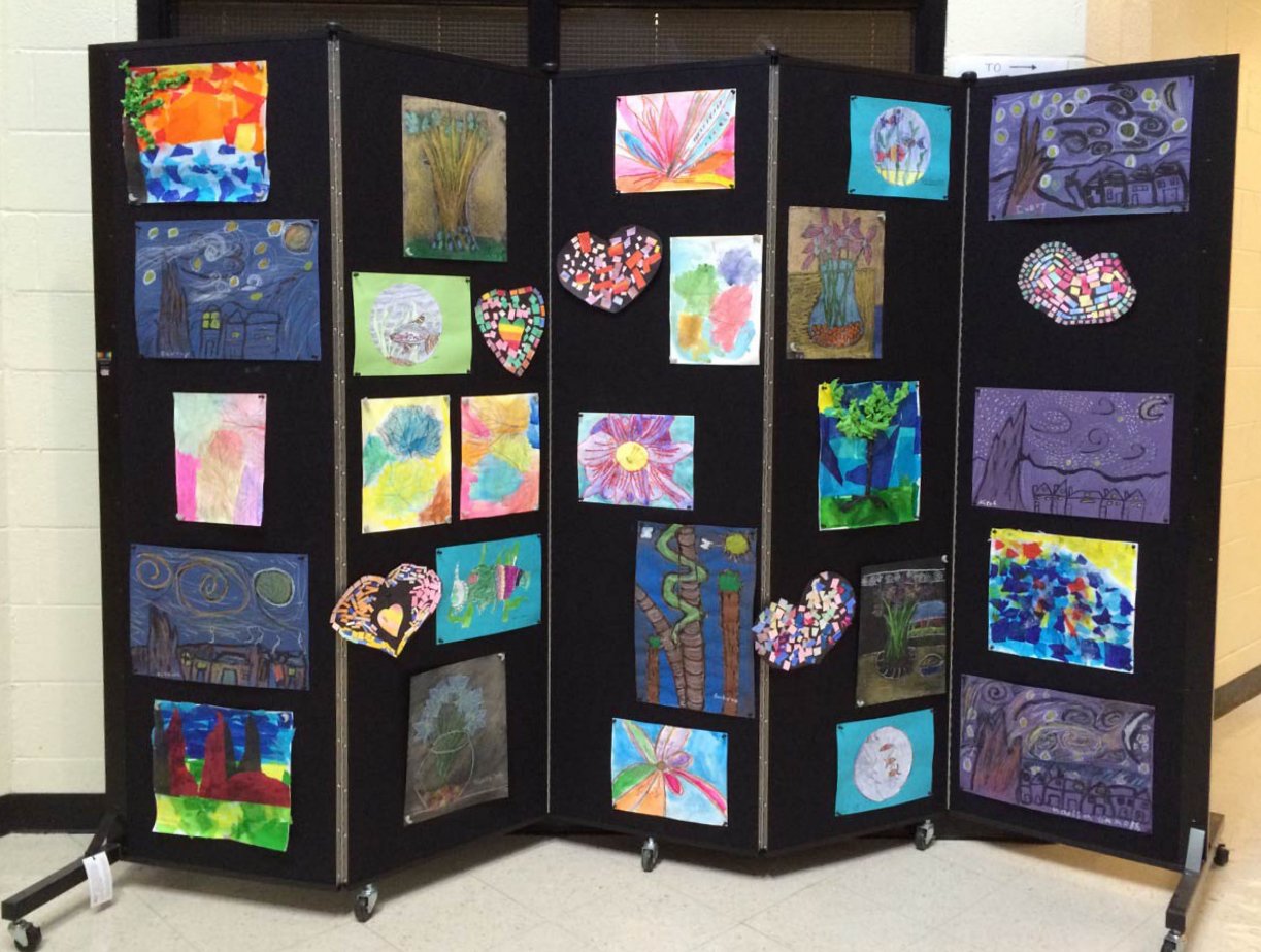 Children's artwork displayed on a black portable wall