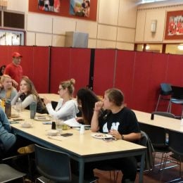 A row of red room partitions divide a cafeteria into two rooms