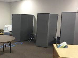 Three classroom partitions separate three desks from each other