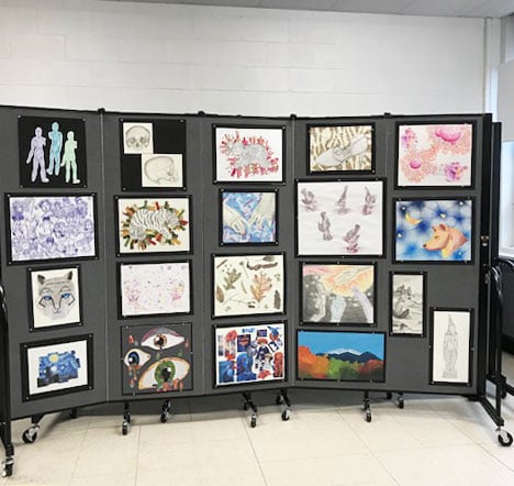 Varying sizes of student artwork displayed on a 5-panel portable wall