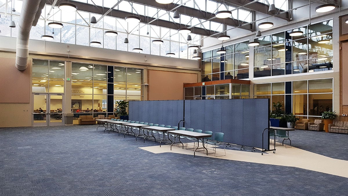 A set up two blue room dividers adjoined to create a division in a large open room