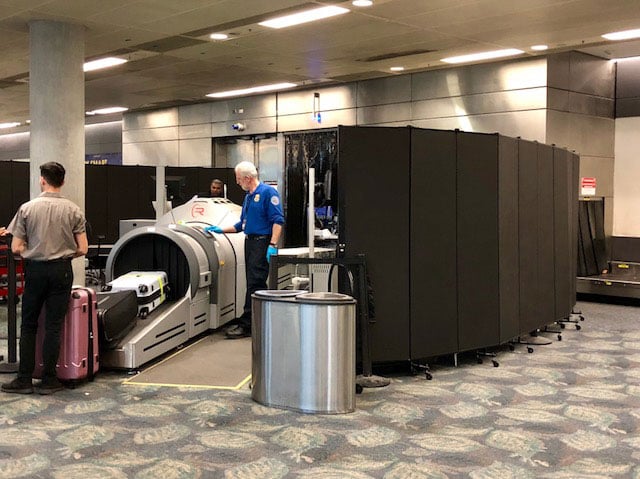 Movable privacy screen around luggage screening