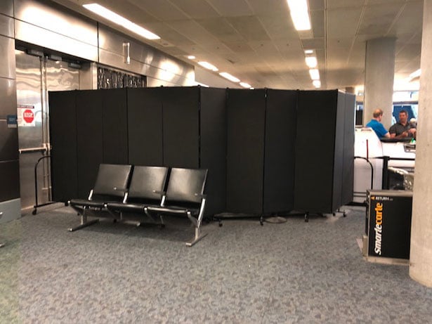 Portable wall configured around airport screening for privacy