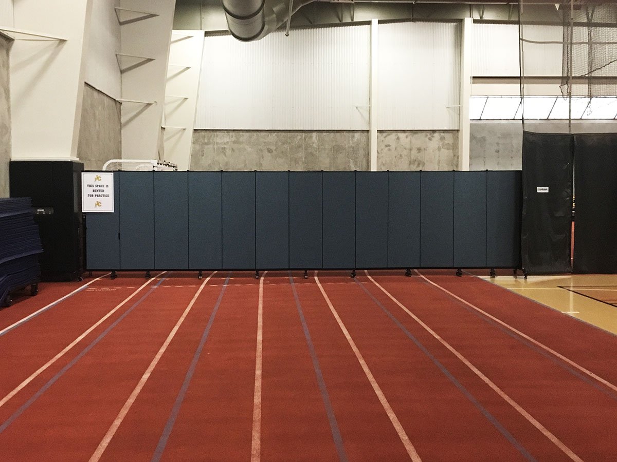 The back of a runner track is hidden by a long room divider