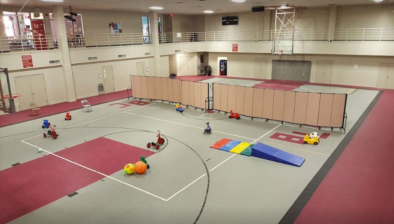 A set of tan room dividers split a gym into two training areas