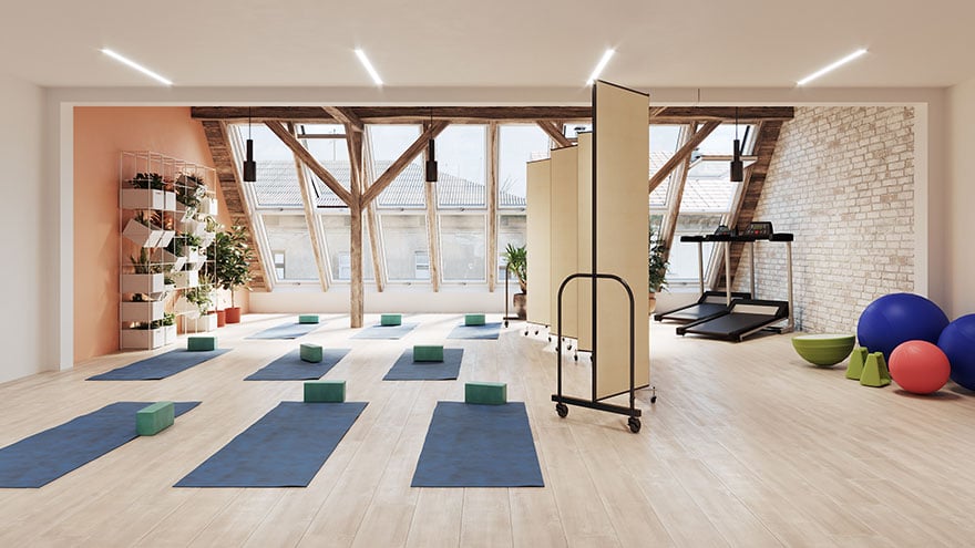 Small fitness studio space divided in two by a beige room divider