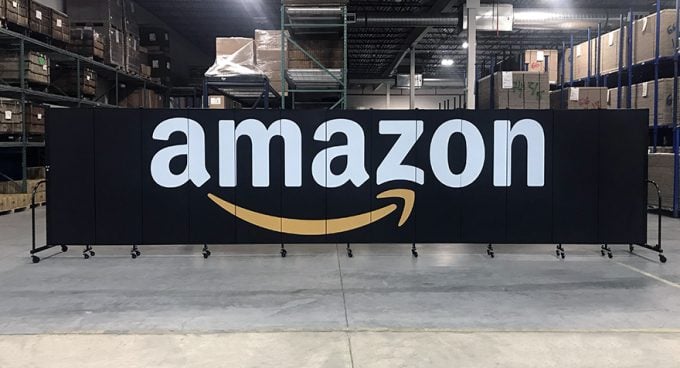 A black room divider with the Amazon logo printed across it