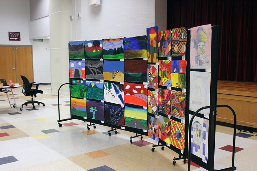 Young students' artwork on display for parent teacher conferences in a gym