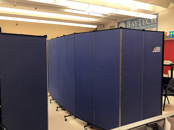 A blue room divider separates a classroom into two areas and a hallway