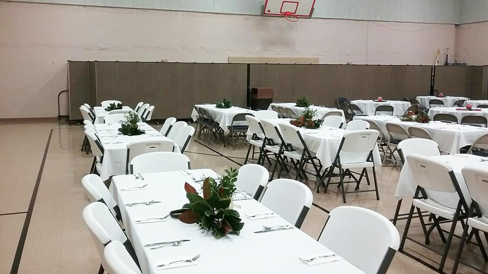 Food prep for a banquet is hidden behind a set of church portable walls